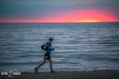 Zawodnik biegnący plażą na tle morza (fot. Jacek Deneka, Ultra Lovers)