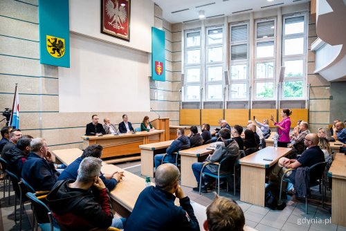Sala obrad Rady Miasta w Urzędzie Miasta Gdyni, kilkadziesiąt osób siedzi w ławach, na środku Aleksandra Kosiorek, Rafał Geremek, Krzysztof Cieśliński i mecenas.
