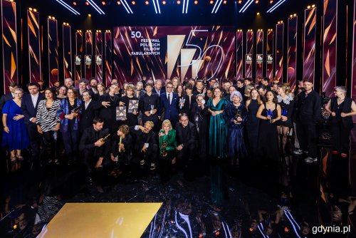Scena Teatru Muzycznego, dekoracje FPFF, duża grupa ludzi nagrodzonych na gali pozuje do zdjęcia
