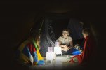 Dzieci w oświetlonym latarkami namiocie.