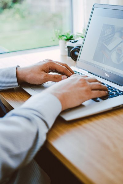 Osoba używająca laptopa, zbliżenie na ręce na klawiaturze