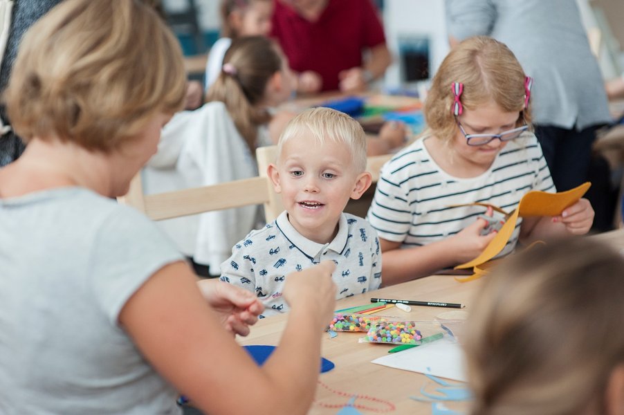 Chłopiec o blond włosach i niebieskich oczach podczas zajęć w sali