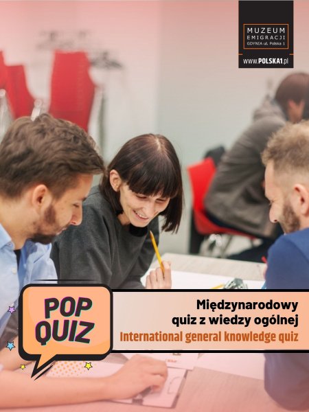 Grupa ludzi rozwiązująca quiz przy stole, na dole belka z napisem 