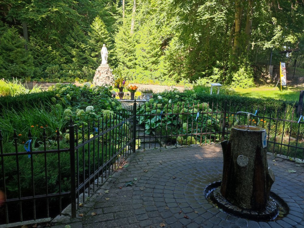 Widok na źródełko w wodą oraz figurkę Marii