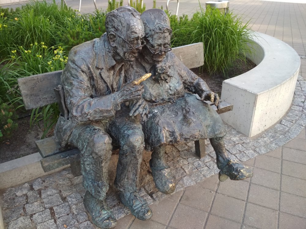 Rzeźba przedstawiająca parę kaszubów siedzących na ławeczce