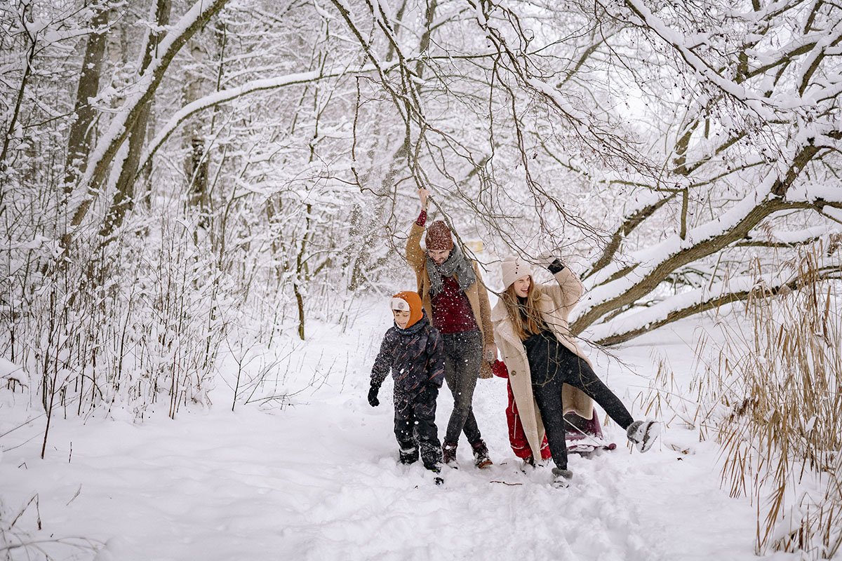 na zdjęciu rodzina bawiąca się w śniegu