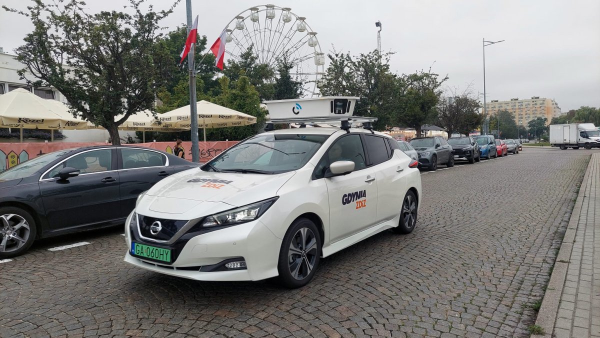 Pojazd do mobilnych kontroli na ulicach Gdyni, białe auto z logo, ulica