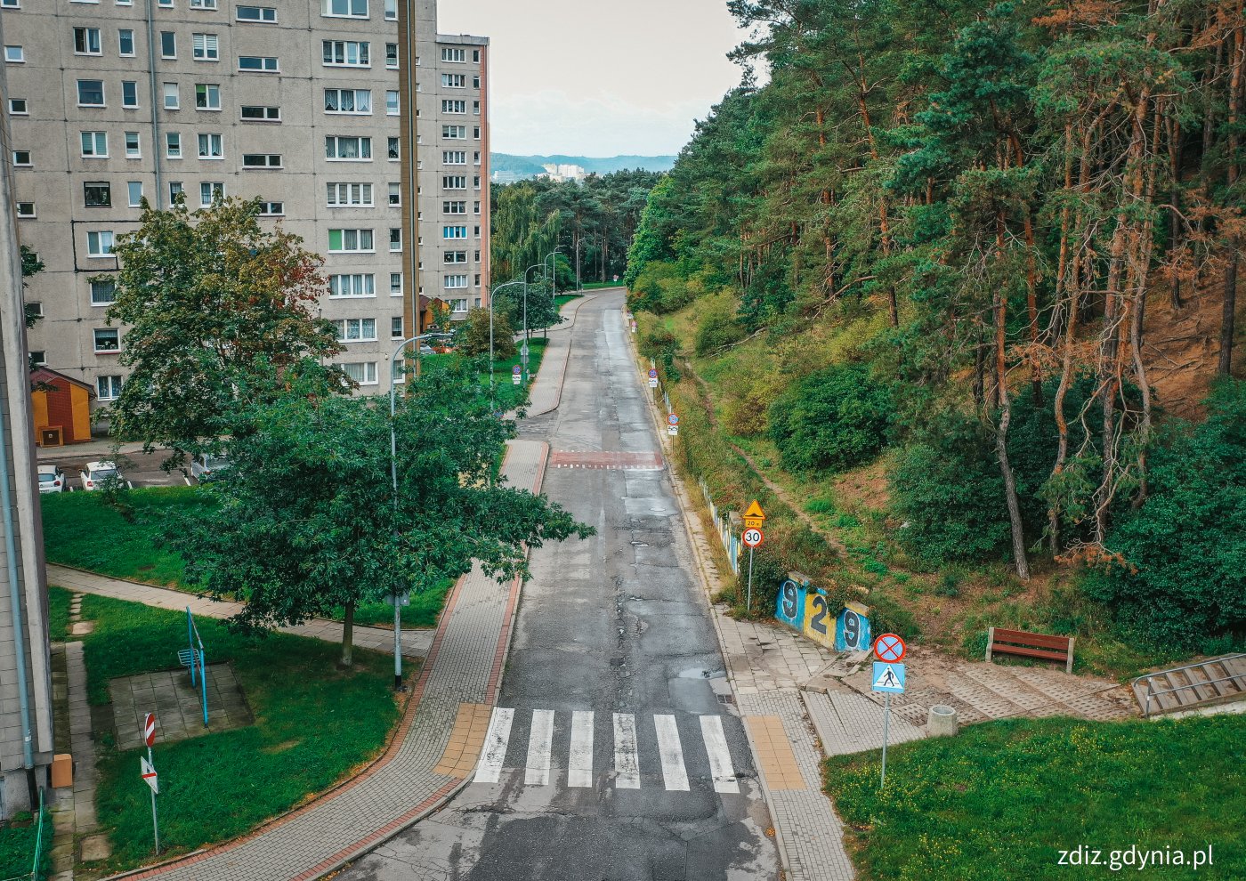 widok na jezdnię z góry, w tle zieleń oraz bloki