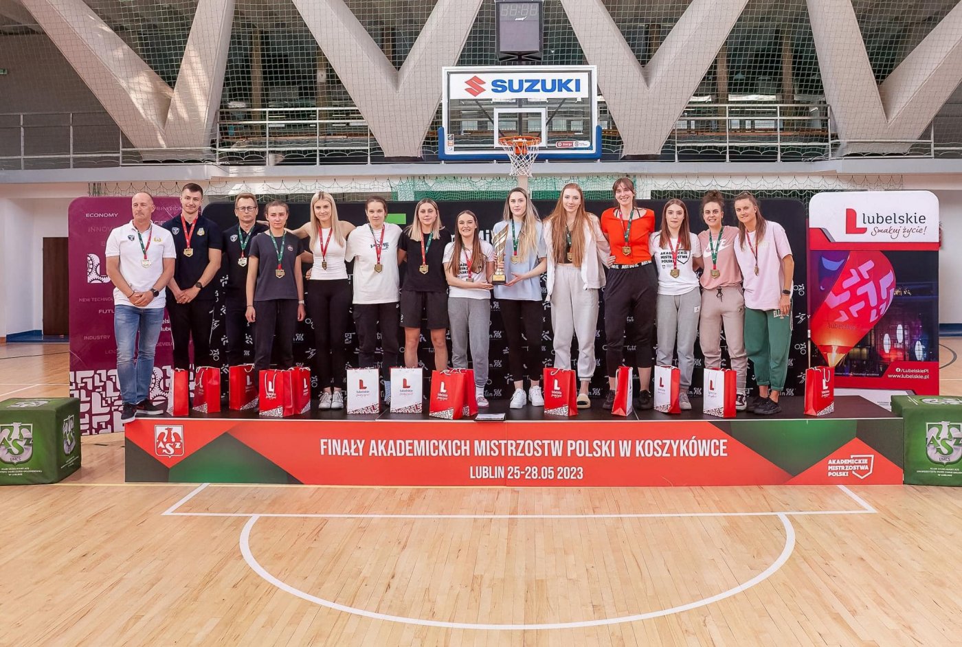 zawodnicy AMW Gdynia na podium odbierający nagrodę za zdobycie 1. miejsca w Akademickich Mistrzostwach Polski w koszykówce 5x5.