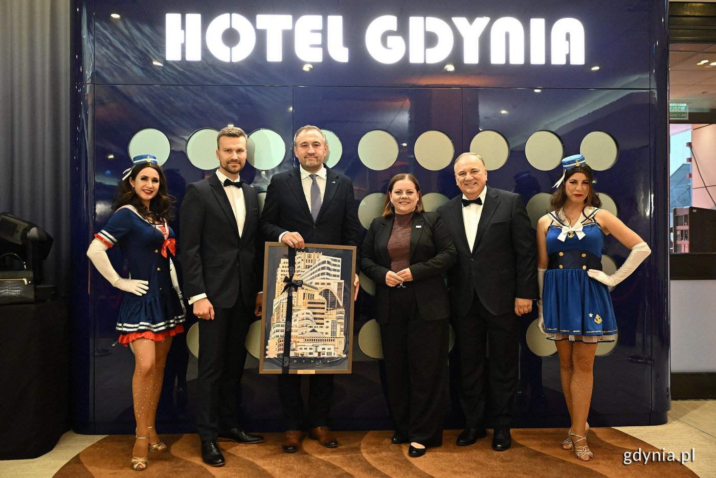 Na zdjęciu m.in.: Michał Woźnicki, zastępca dyrektora Hotelu Mercure Gdynia Centrum, wiceprezydent Gdyni Tomasz Augustyniak, prezydent Gdyni Aleksandra Kosiorek oraz Krzysztof Arcyman, dyrektor Mercure Gdynia Centrum, z upominkiem przekazanym z okazji ponownego otwarcia obiektu po modernizacji (fot. Michał Puszczewicz)
