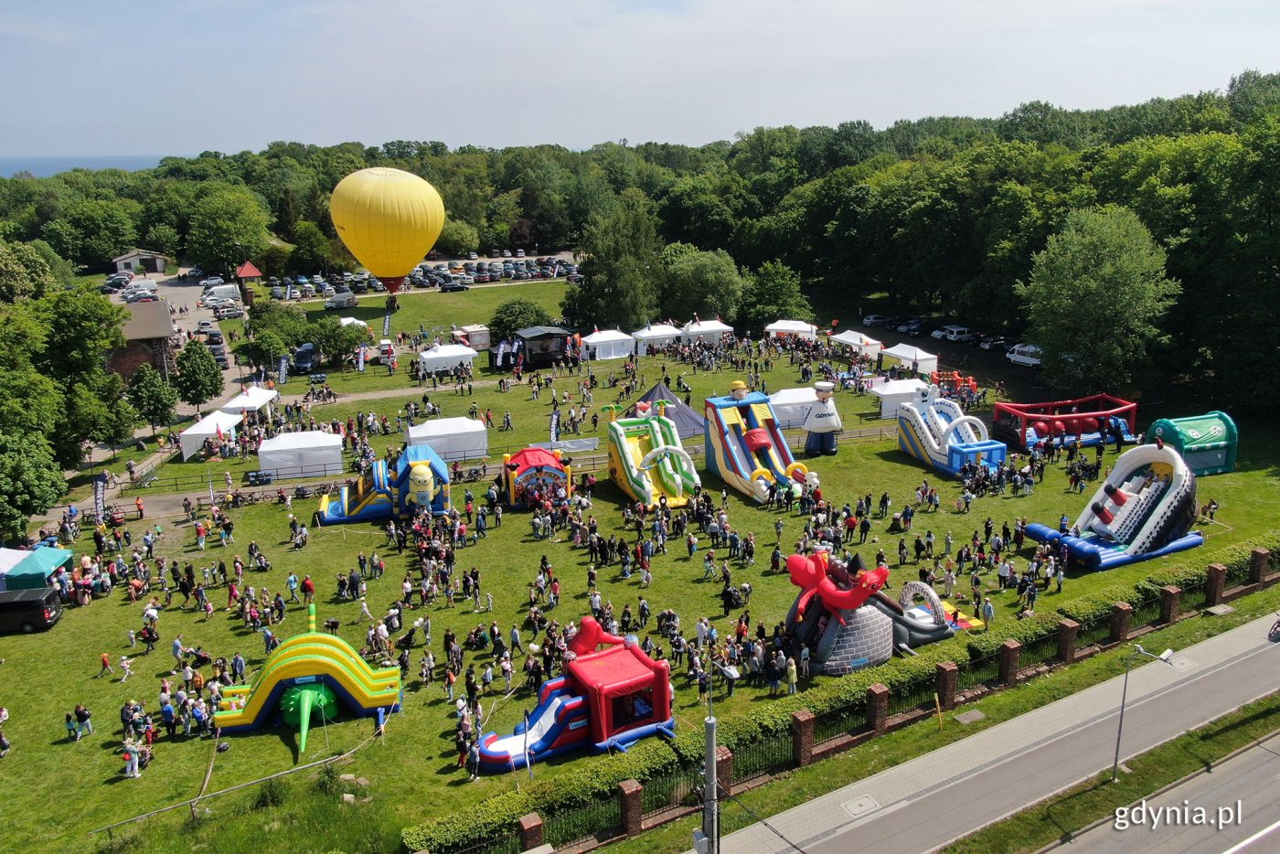 Zdjęcie z lotu ptaka. Park w Kolibkach, słoneczny dzień, dmuchane zabawki i ludzie na festynie