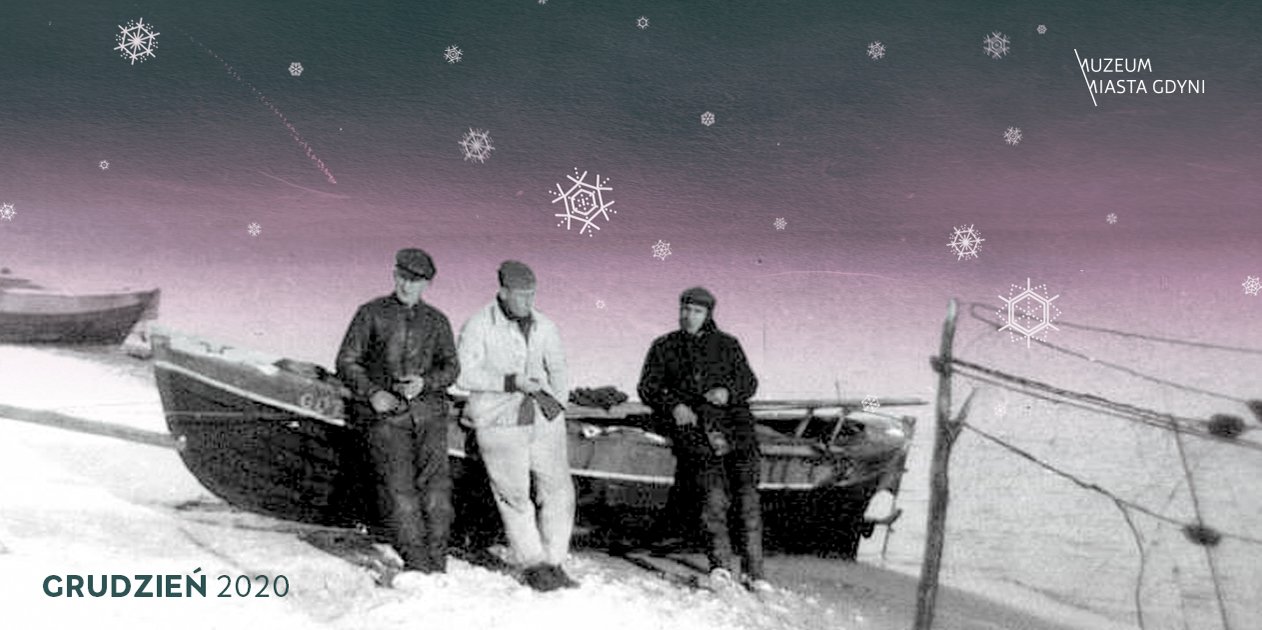 Na archiwalnym zdjęciu trzech mężczyzn stoi opartych o łódkę. Jest zima i napadał śnieg