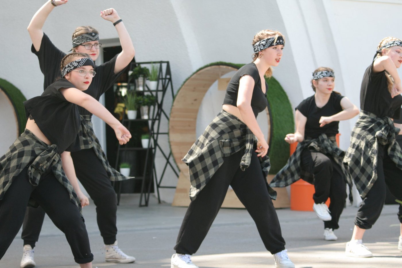 Zdjęcie z pierwszej edycji festiwalu. Grupa nastolatek w sportowych strojach tańcząca i śpiewająca w muszli koncertowej na placu Grunwaldzkim