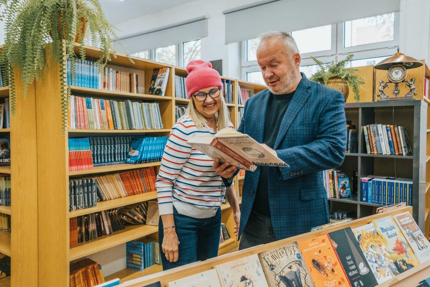 Mężczyzna i kobieta z książką w bibilotece