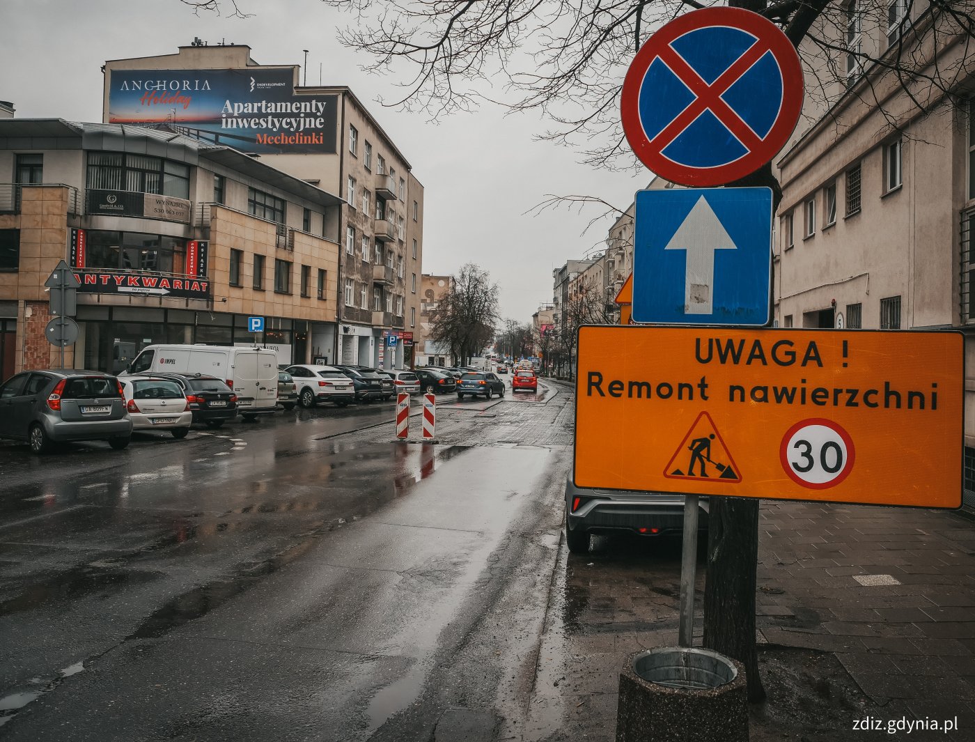 trwające roboty drogowe, widoczny znak informujący o robotach nawierzchni, ograniczenie prędkości. Wymiana nawierzchni.