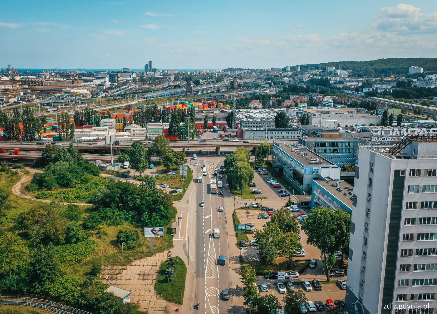 widok z góry na ulicę, widoczny ruch uliczny, budynki w tle
