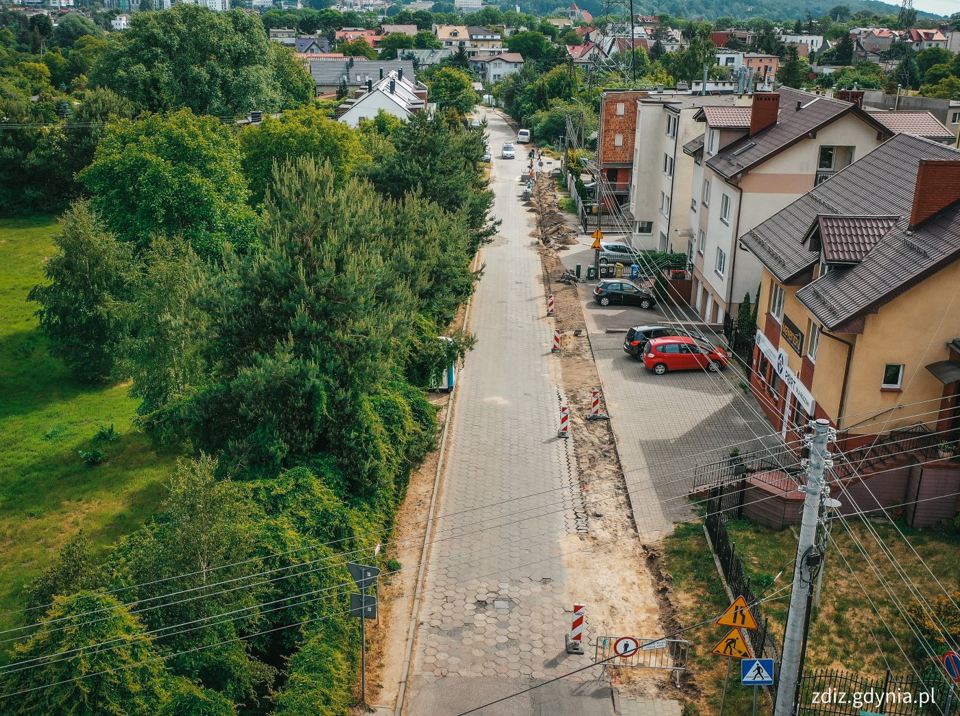 widok z góry na drogę, trwający remont chodnika, widoczna jezdnia, zieleń oraz budynki