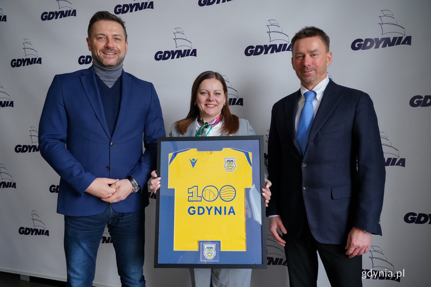 Wojciech Pertkiewicz – prezes zarządu Arki Gdynia oraz Marcin Gruchała – większościowy akcjonariusz klubu przekazali pamiątkową koszulkę z okazji stulecia Gdyni na ręce prezydent Aleksandry Kosiorek (fot. Magdalena Czernek)