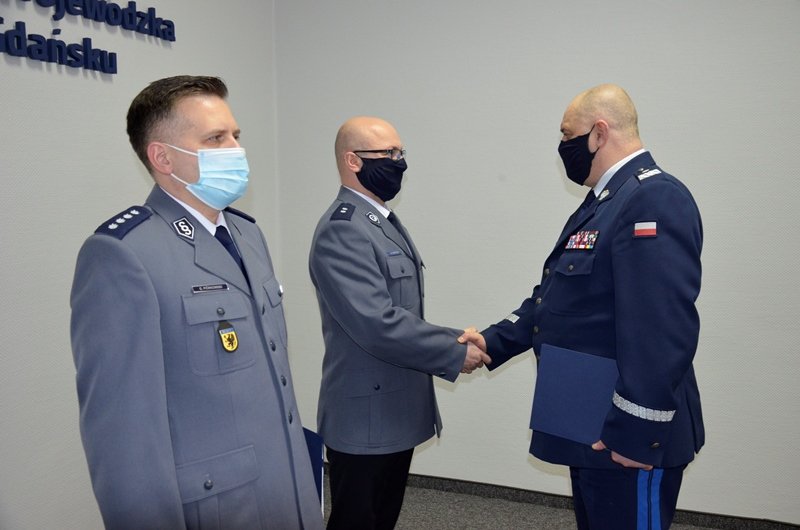 Od lewej: nadkom. Grzegorz Piórkowski – pierwszy zastępca Komendanta Miejskiego Policji w Gdyni i podkom. Adam Nastały – zastępca Komendanta Miejskiego Policji w Gdyni, któremu gratuluje nadinsp. Andrzej Łapiński – Komendant Wojewódzki Policji w Gdańsku // fot. KMP w Gdyni