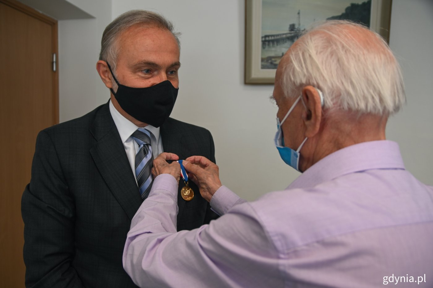 prof. Jerzy Grzywacz - prezes okręgu pomorskiego Światowego Związku Żołnierzy Armii Krajowej przypina medal prezydentowi Wojciechowi Szczurkowi  // fot. Marcin Mielewski