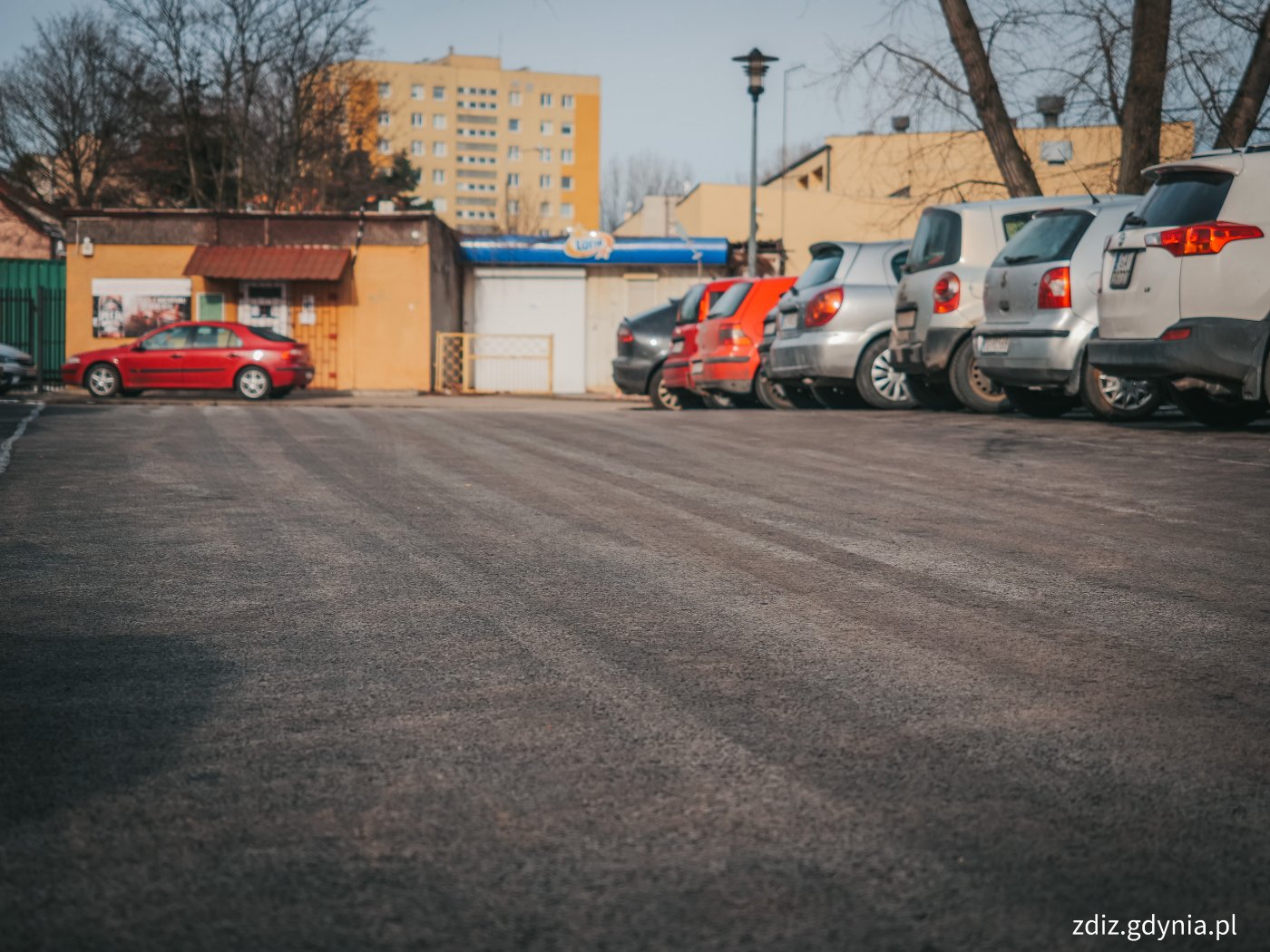 nowa nawierzchnia parkingu, asfalt, widoczne w tle zaparkowane samochody