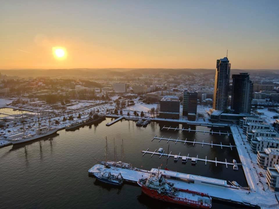 Zdjęcie lotnicze Śródmieścia Gdyni od strony zatoki - widoczna marina, Sea Tower i część dzielnicy oraz zachodzące słońce