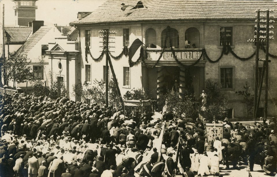 Fotografia czarno-biała na karcie pocztówkowej autorstwa Romana Morawskiego wykonana podczas uroczystości Bożego Ciała na ulicy Starowiejskiej – skrzyżowanie z Placem Kaszubskim. Zdjęcie przedstawia tłum wiernych klęczących przy jednym z ołtarzy podczas procesji Bożego Ciała. Widoczne dziewczynki sypiące kwiatki, w białych sukienkach, osoby niosące sztandary czy kapłan pod baldachimem. Tłum skierowany jest w stronę głównego wejścia Domu i Kaplicy Sióstr Miłosierdzia Wincentego a Paolo, który udekorowany jest girlandami, z flagą państwową, wokół budynku ustawione są młode brzózki, a w gzymsie nad wejściem mieści się napis: „ZRÓBCIE MIEJSCE PAN IDZIE Z NIEBA”. Po prawej stronie, przed wejściem stoi figurka Chrystusa. W głębi, po lewej stronie, zza budynków wystaje wieża Straży Pożarnej.