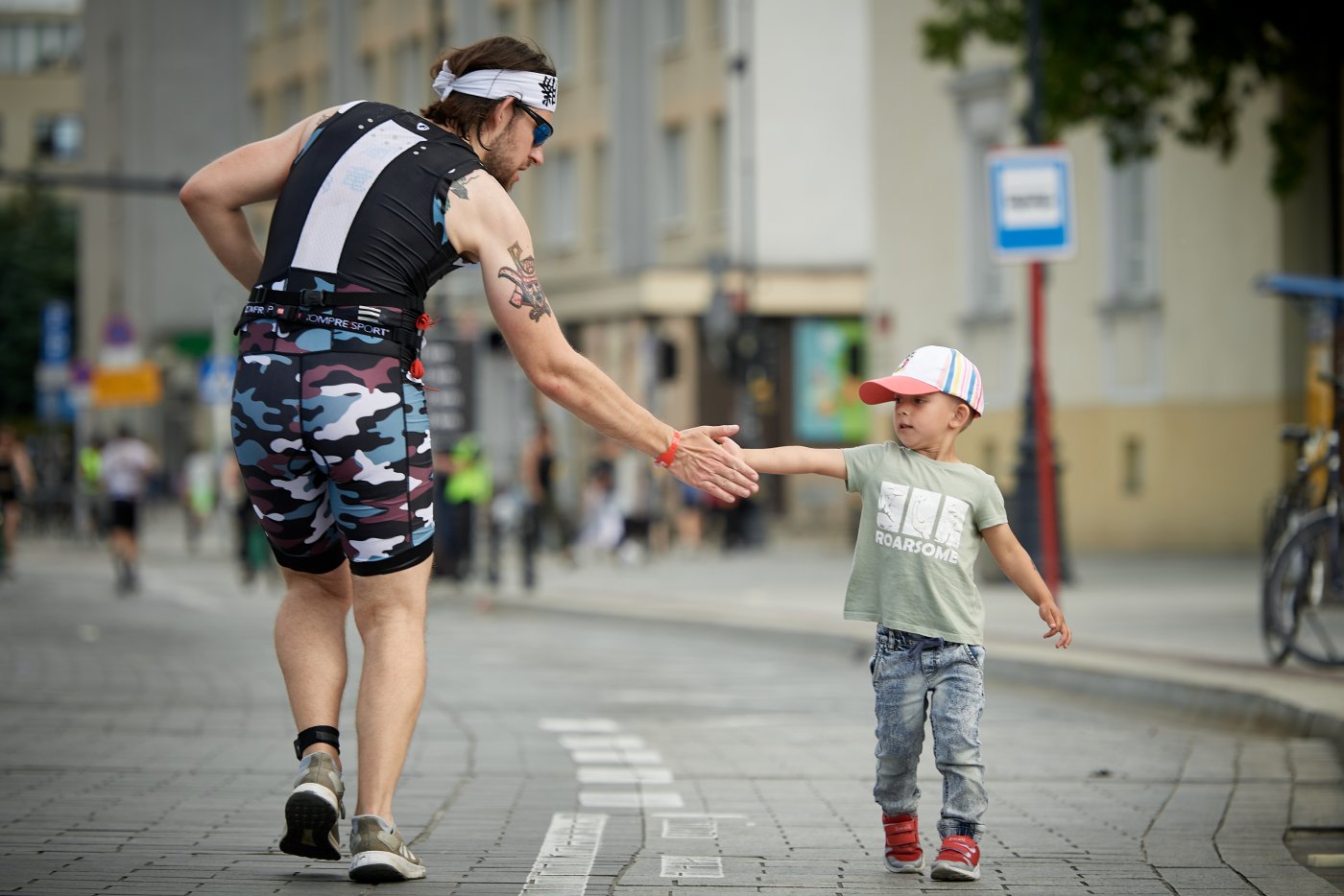 Triathlonista podający dłoń dziecku na trasie (fot. Sport Evolution)