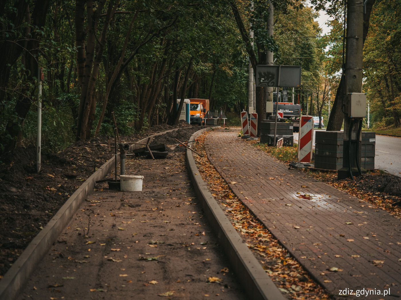 roboty drogowe, trwa układanie chodnika, w tle jezdnia, zieleń