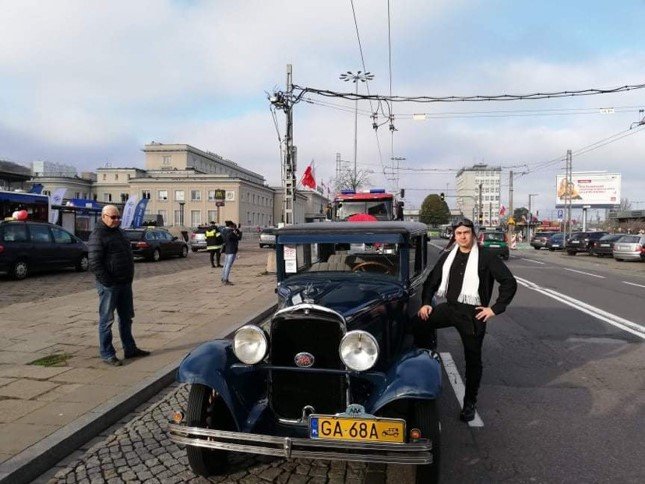 Nauczyciel na tle zabytkowego samochodu.