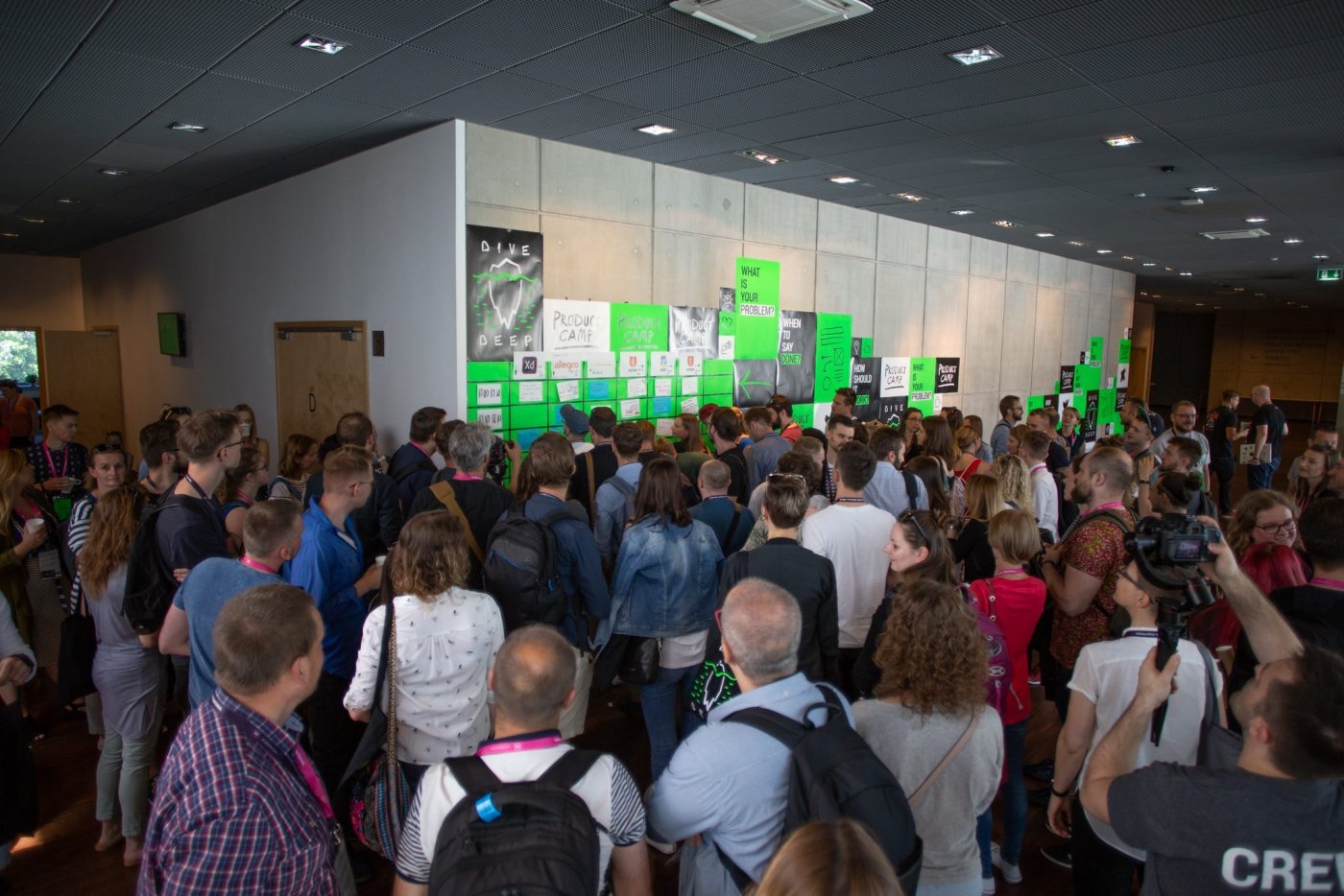 Korytarz PPNT Gdynia. Tłum ludzi w kierunku ściany z zielonymi plakatami