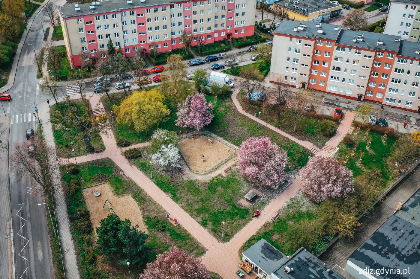 widok z góry na skwer, widoczny plac zabaw, zieleń, drzewa i bloki