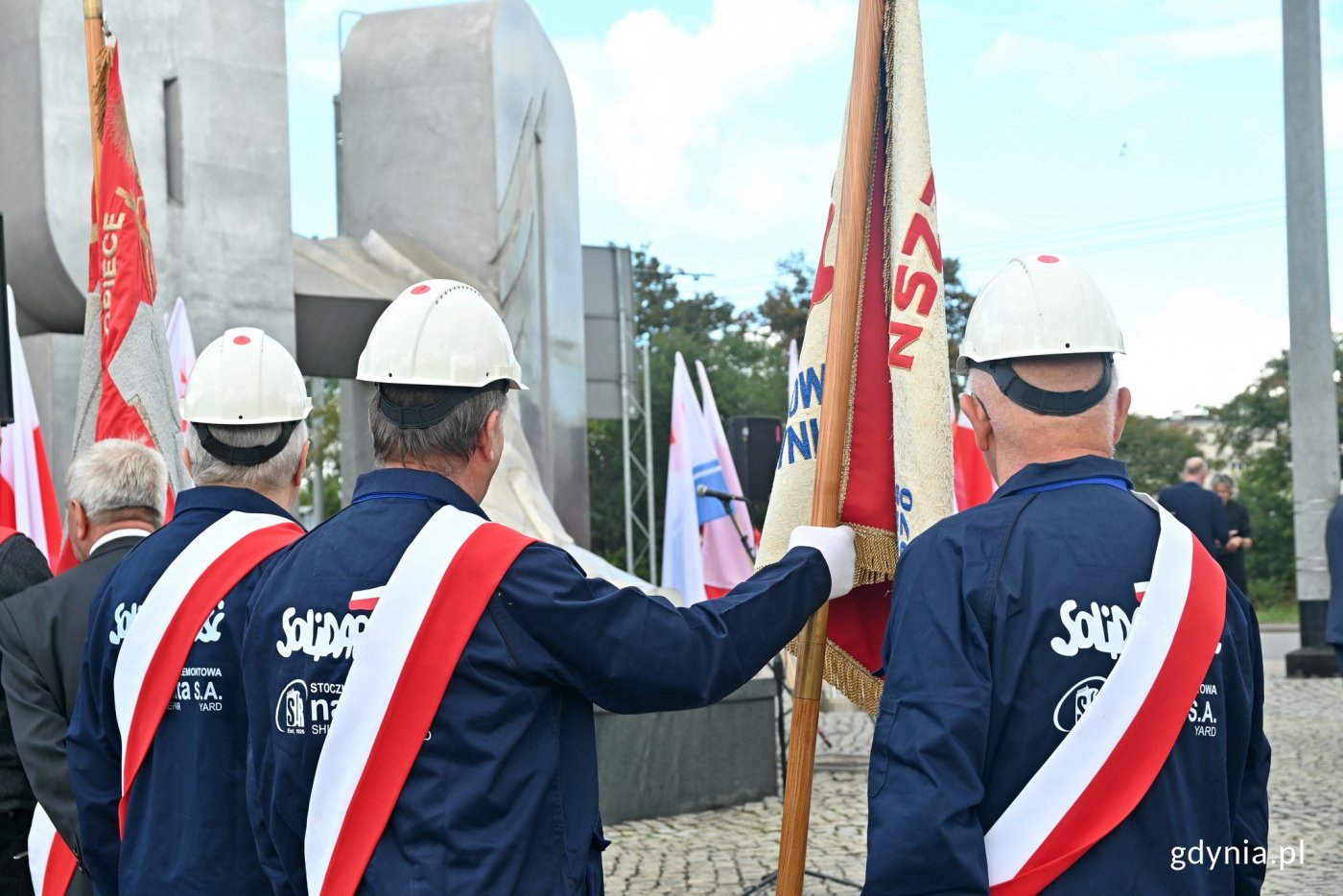 Poczet sztandarowy NSZZ „Solidarność” Stoczni Nauta przed pomnikiem Ofiar Grudnia '70 podczas uroczystości upamiętniających wydarzenia Sierpnia '80