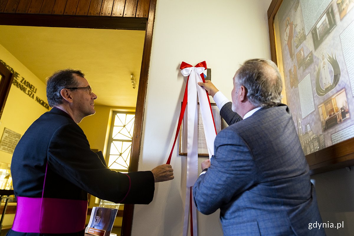 Prezydent Gdyni Wojciech Szczurek i ks. Jacek Bramorski, proboszcz parafii NSPJ odsłaniają tabliczkę 