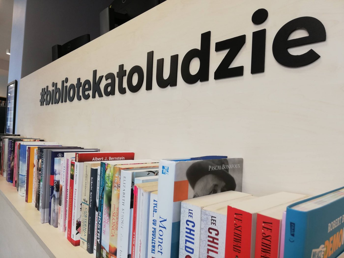 Półka z książkami w Bibliotece Gdynia i hasło #bibliotekatoludzie. Fot. Archiwum Biblioteki Gdynia