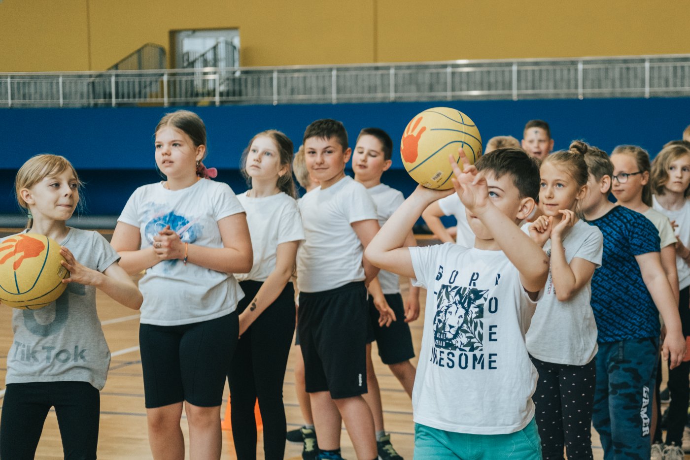 Dzieci w strojach sportowych z piłką