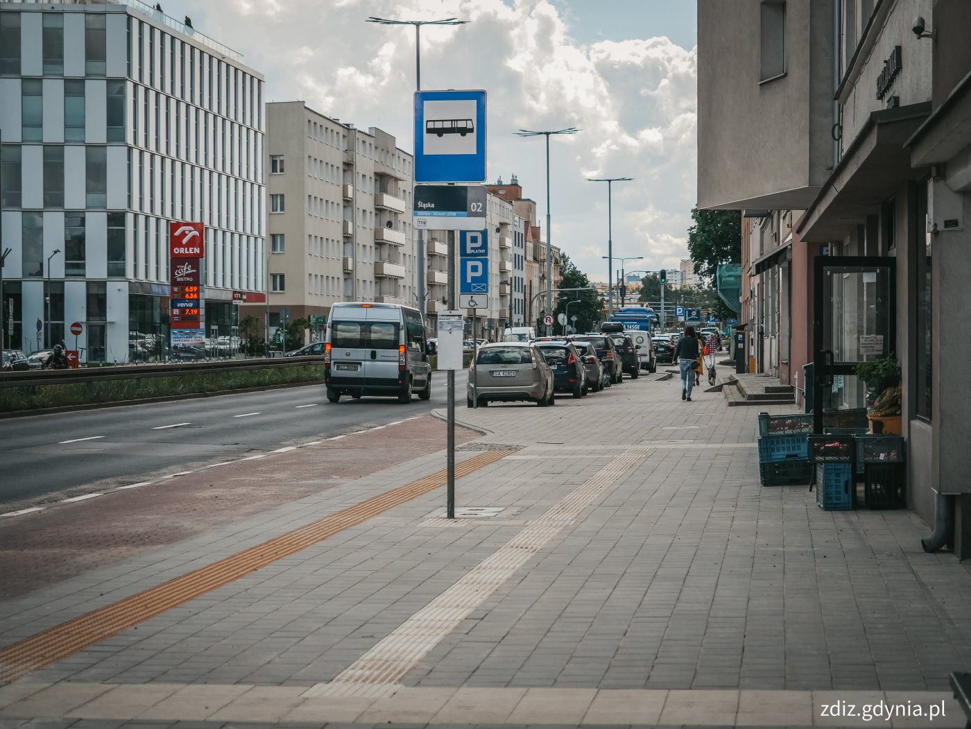 chodnik po remoncie, widoczna zatoka autobusowa, znak, chodnik z kostki i nawierzchnia fakturowana