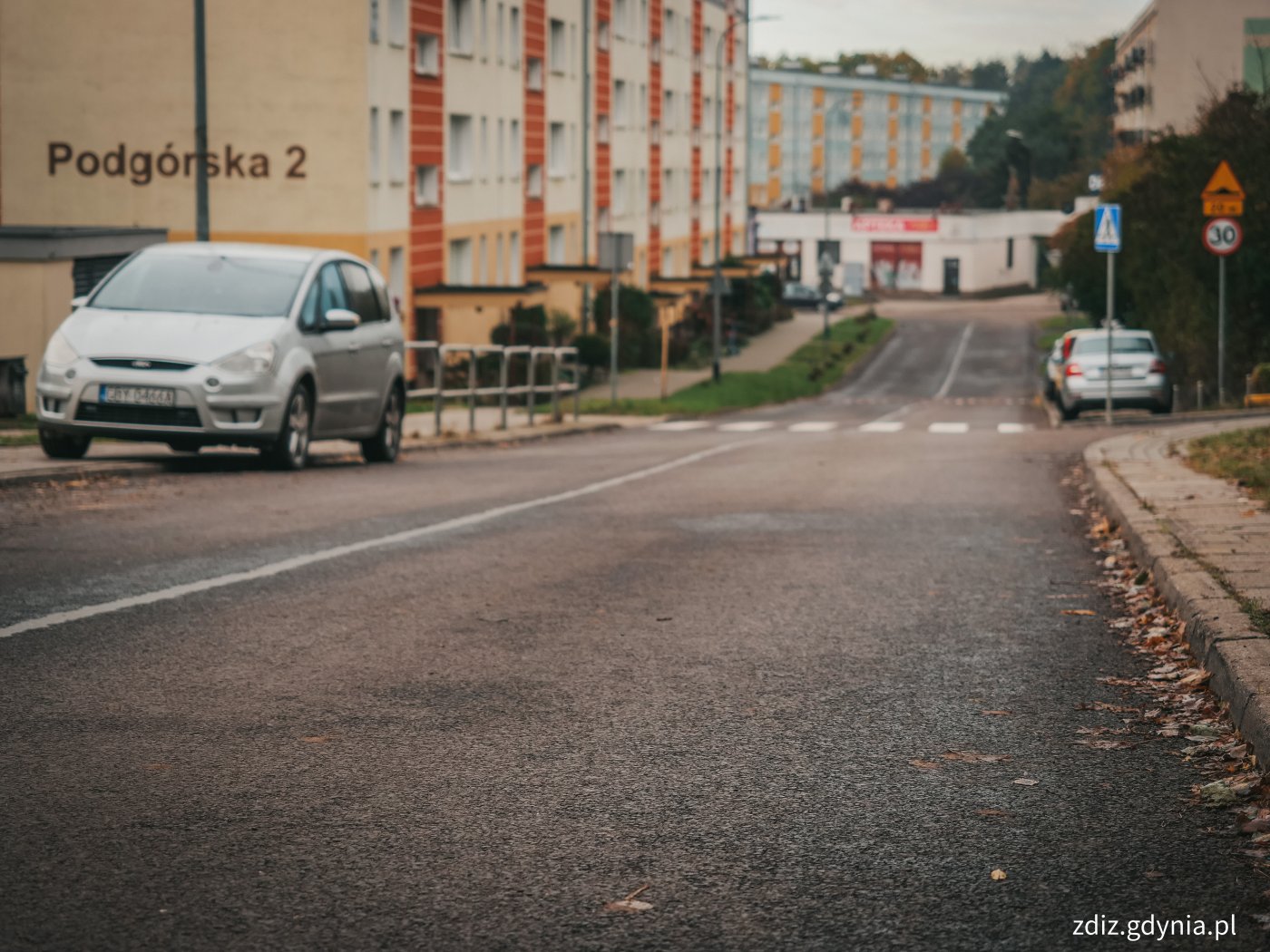 jezdnia z nową nawierzchnią, w tle chodnik oraz bloki