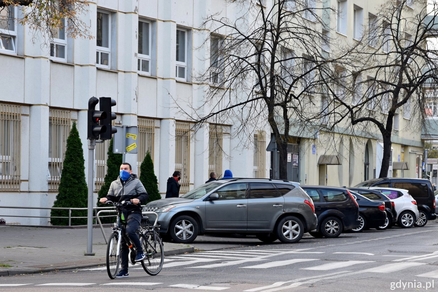 Rowerzysta w Gdyni stojący za przejściem dla pieszych na czerwonym świetle, zanim widać zaparkowane samochody . Fot. Paweł Kukla