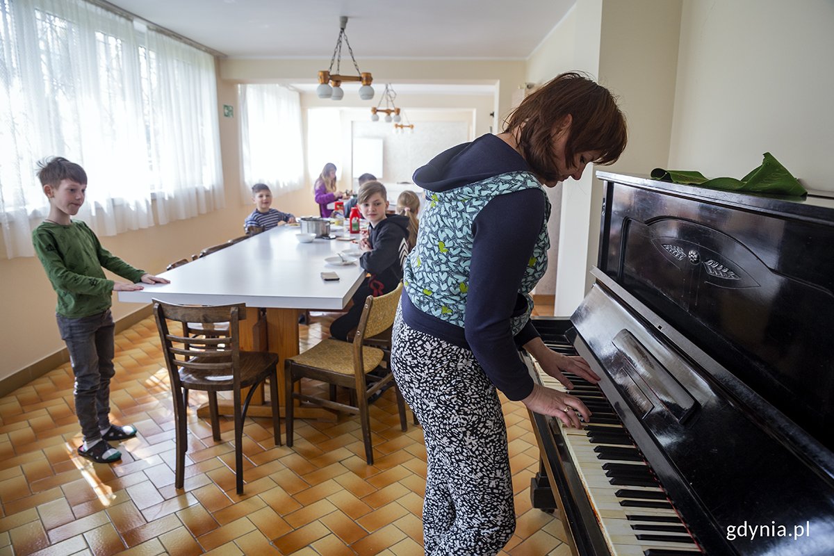 Swieta spod Charkowa przygrywa dzieciom na pianinie podczas posiłku. Fot. Przemysław Kozłowski