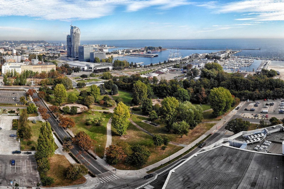 Zdjęcie przedstawia Park Rady Europy w Gdyni z lotu ptaka, w tle widoczna m.in. marina i Sea Towers