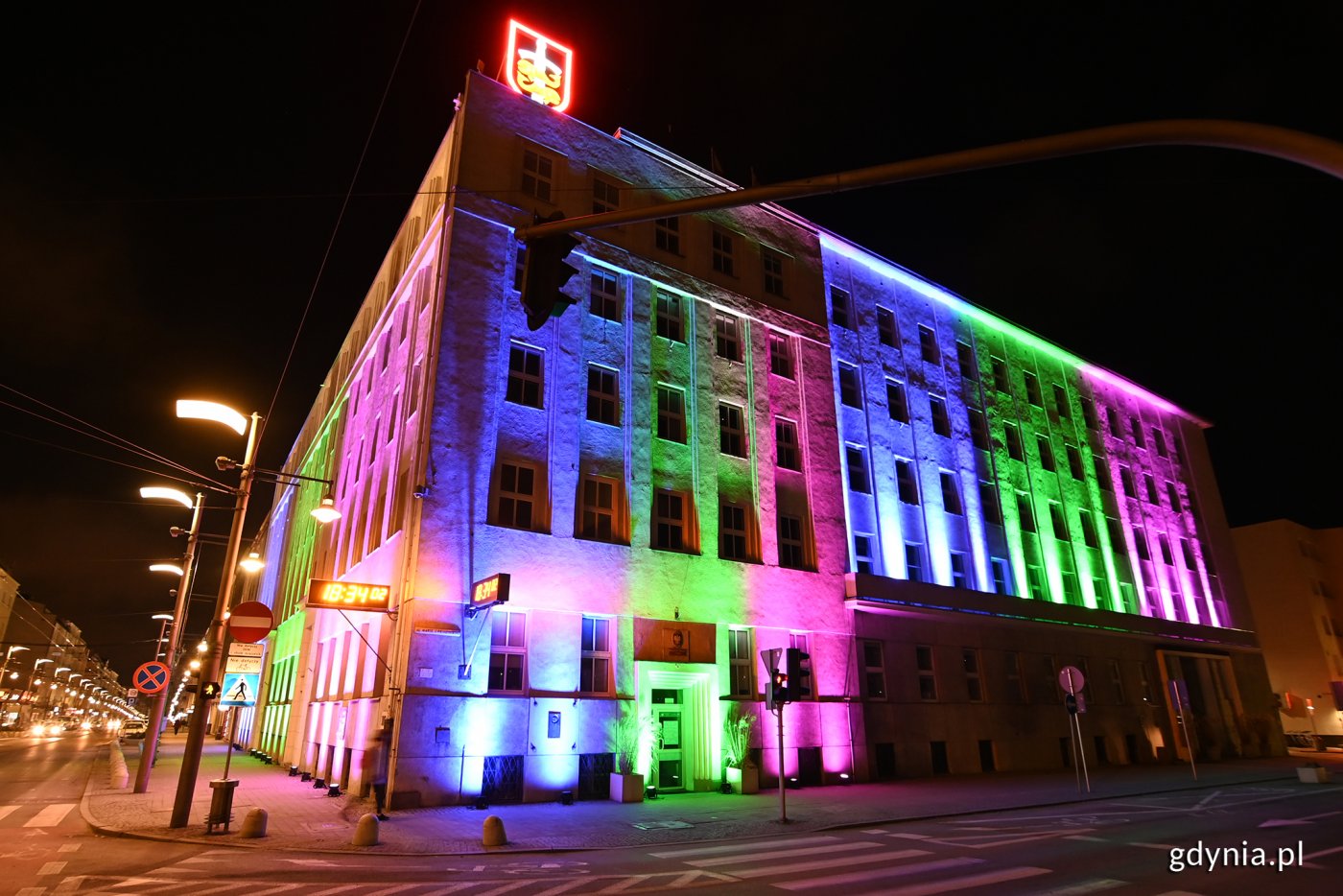 Róg budynku Urzędu Miasta Gdynia przy Świętojańskiej i alei Piłsudskiego. Elewacja podświetlona na kolory: niebieski, różowy i zielony.