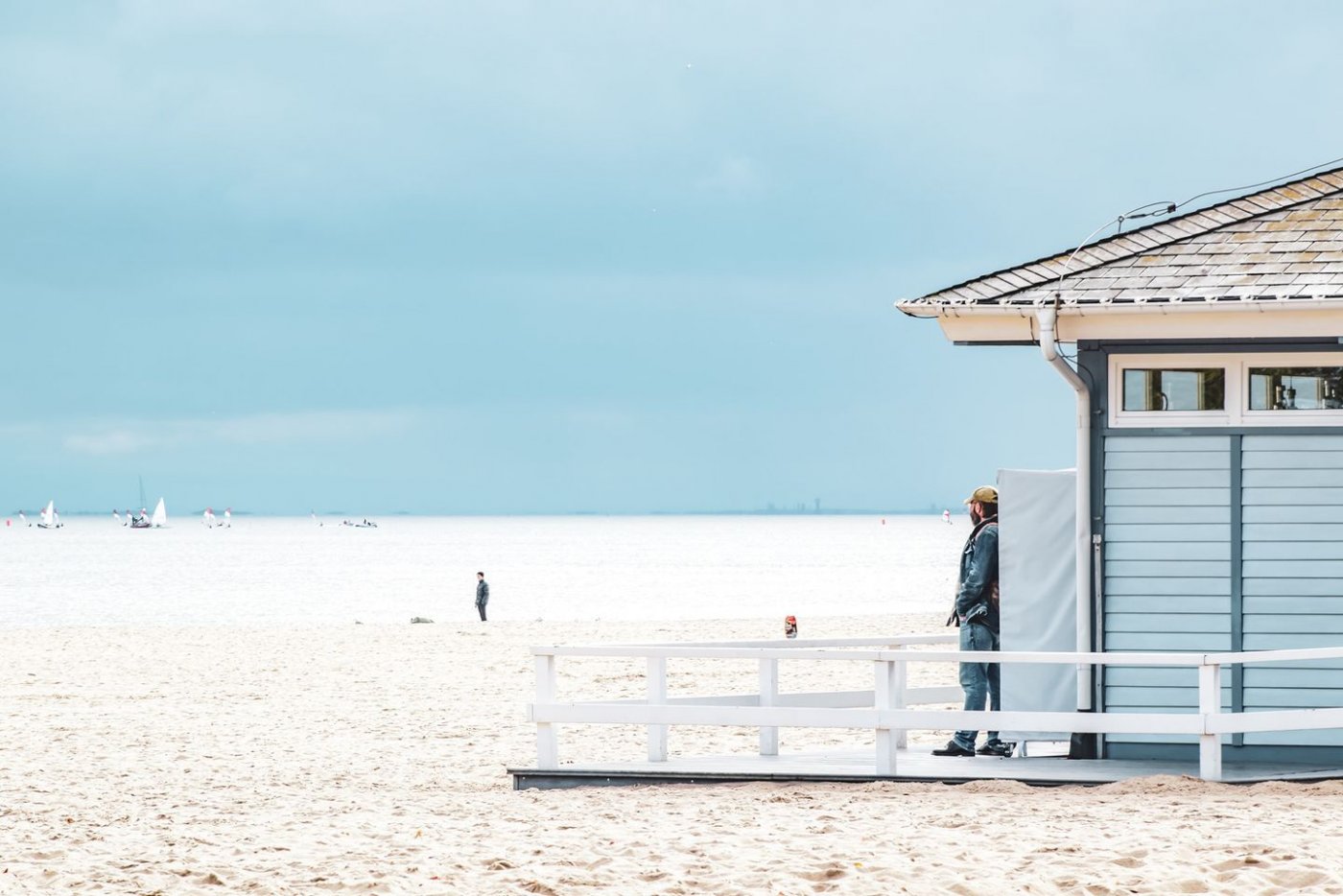 na zdjęciu mężczyzna stojący przed kafejką na plaży