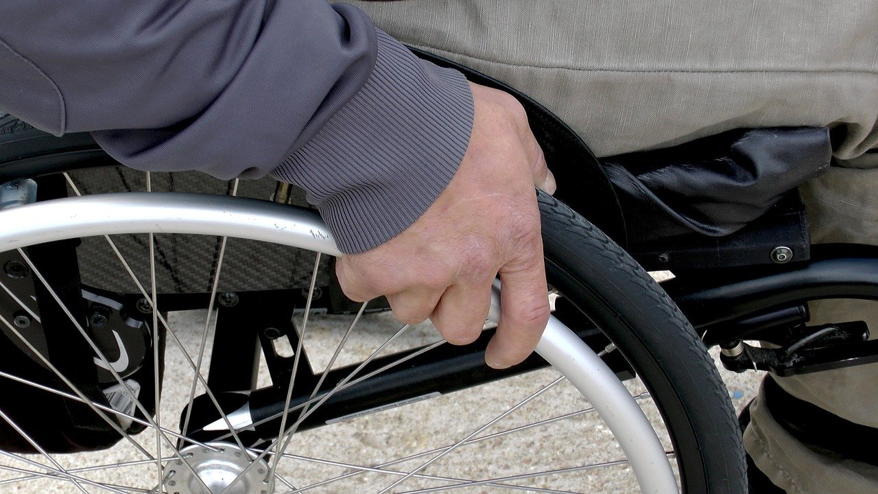 Ręka na kole wózka inwalidzkiego