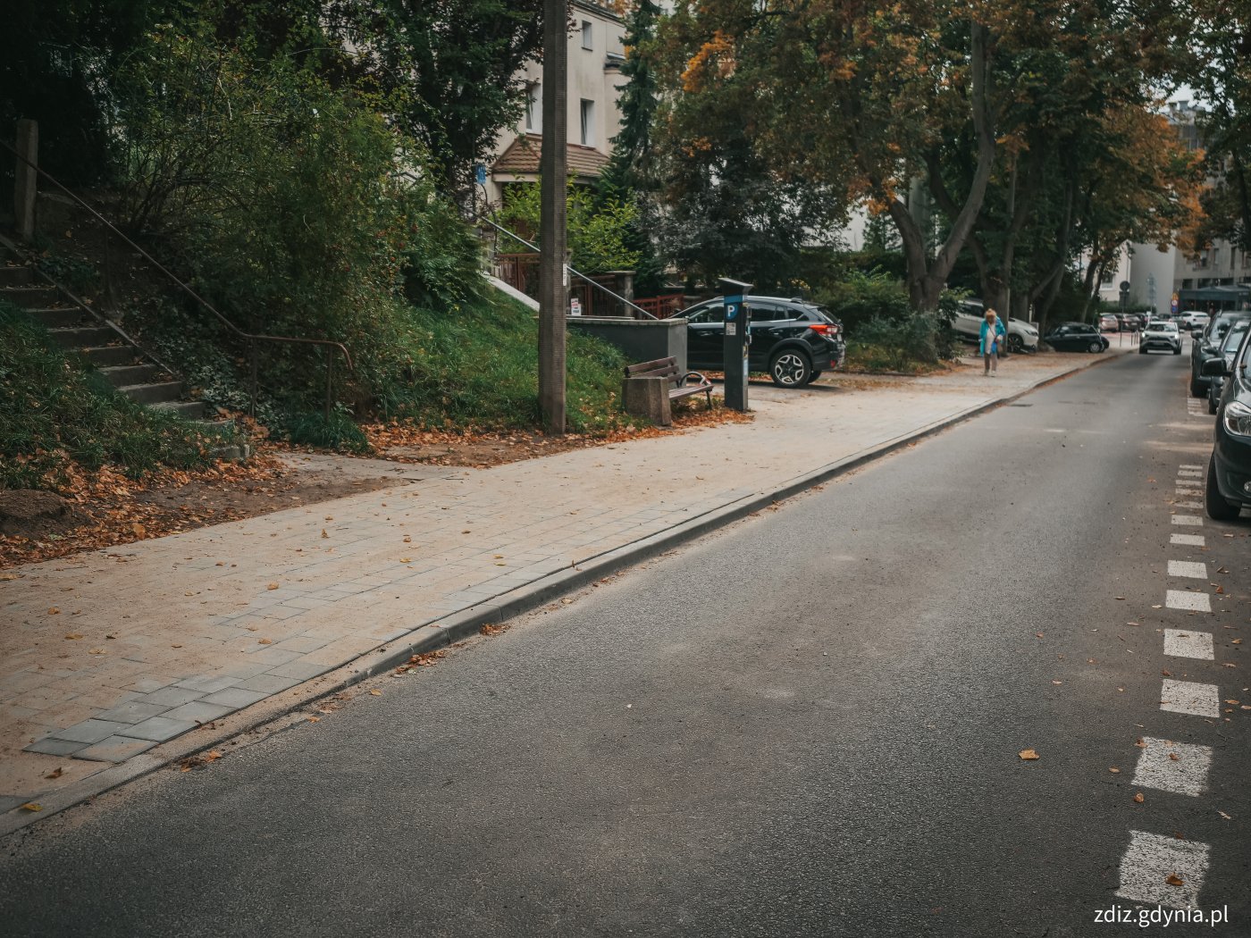widoczna jezdnia oraz chodnik po remoncie, w tle zieleń