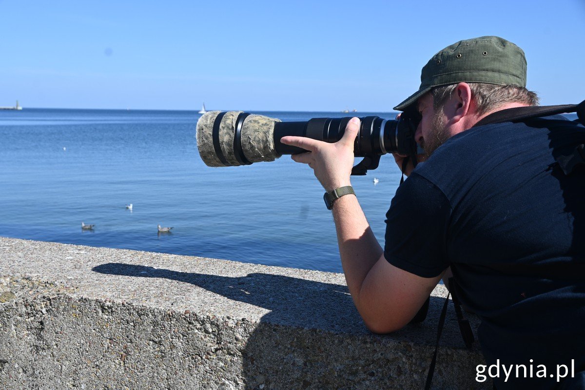 Ornitolog Jakub Typiak obserwuje ptaki na bulwarze Nadmorskim, fot. Magdalena Czernek