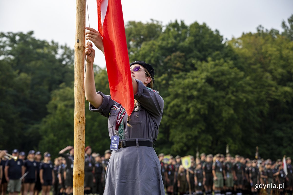 Harcerka podnosi biało-czerwoną flagę na masz na otwarcie Zlotu Okręgu Pomorskiego ZHR. Fot. Przemysław Kozłowski