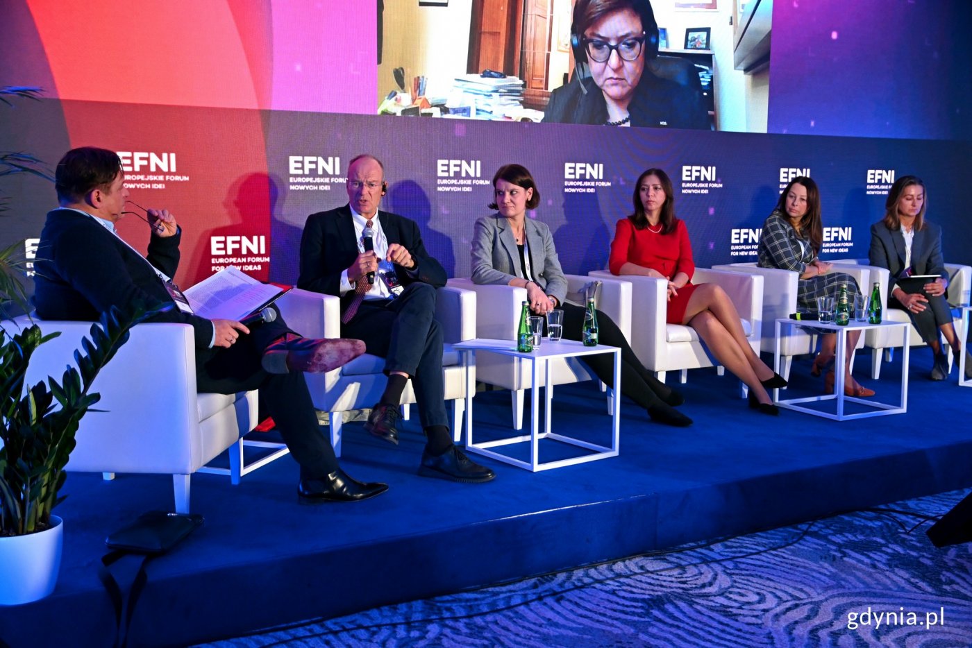 Uczestnicy panelu „Jak wojna w Ukrainie wpływa na rynki pracy?” na Europejskim Forum Nowych Idei. Od lewej: Jacek Męcina – doradca zarządu Konfederacji Lewiatan, Henrik Munthe - przedstawiciel NHO, Katarzyna Gruszecka-Spychała – wiceprezydent Gdyni ds. gospodarki, Katarzyna Łażewska-Hrycko – główny inspektor pracy, Małgorzata Stanowska z firmy Uber, Anna Karaszewska – prezes zarządu Jobs First. U góry, na telebimie łącząca sie online Agnieszka Chłoń-Domińczak – prorektor w Szkole Głównej Handlowej // fot. Magdalena Czernek