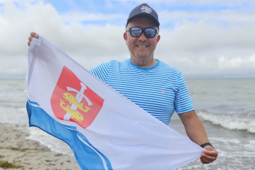 Piotr Biankowski z flagą Gdyni po przepłynięciu Cieśniny Beltquerung (fot. mat. prasowe)