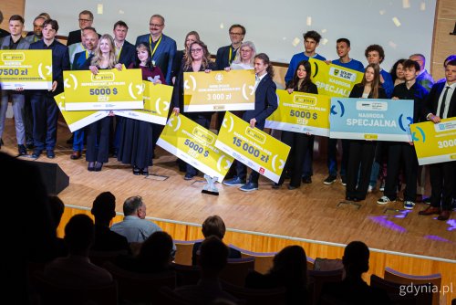 Scena PPNT Gdynia, grupa nastolatków pozuje do zdjęcia, trzymają żółte plansze z nazwami nagród